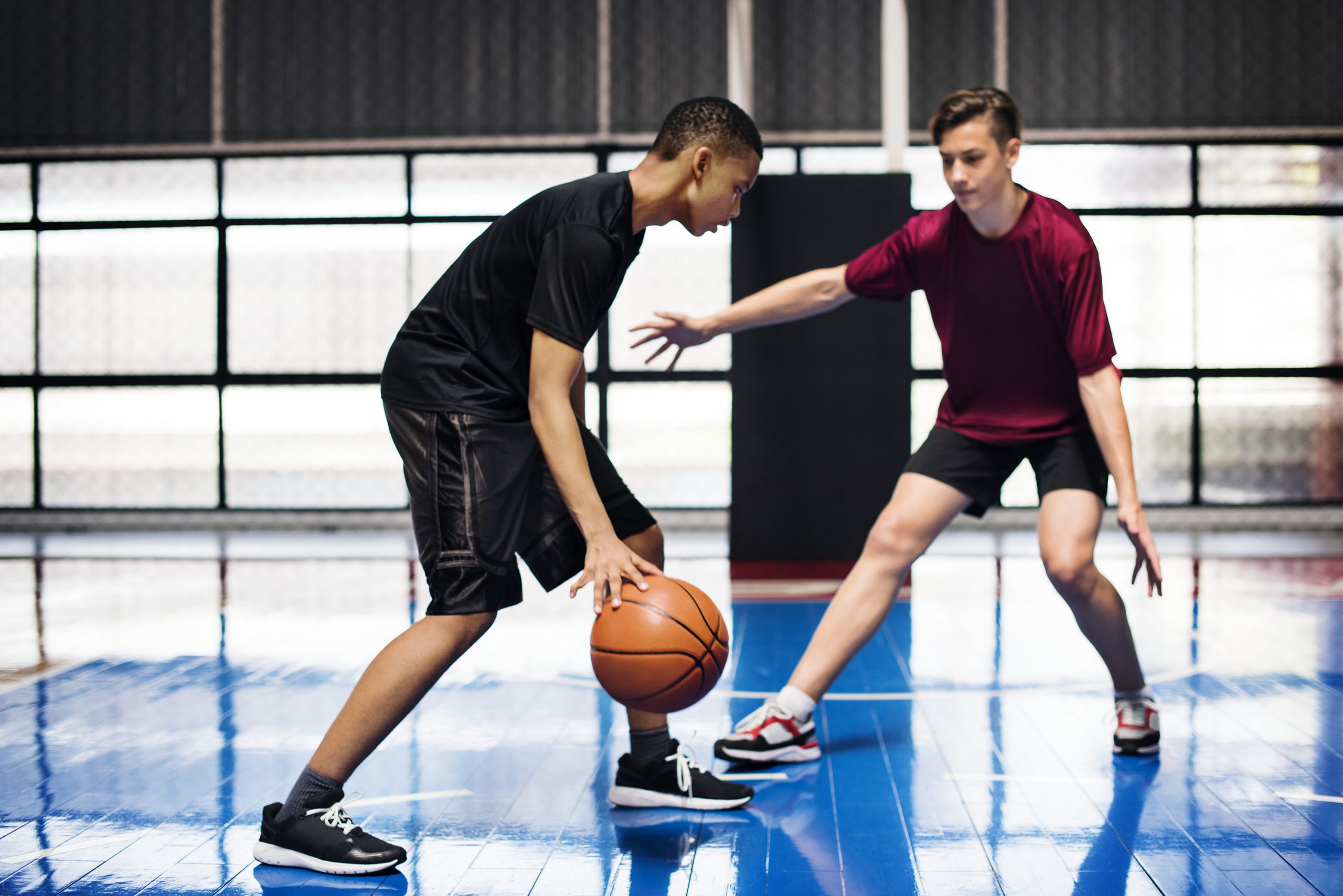 two teenage boys playing basketball